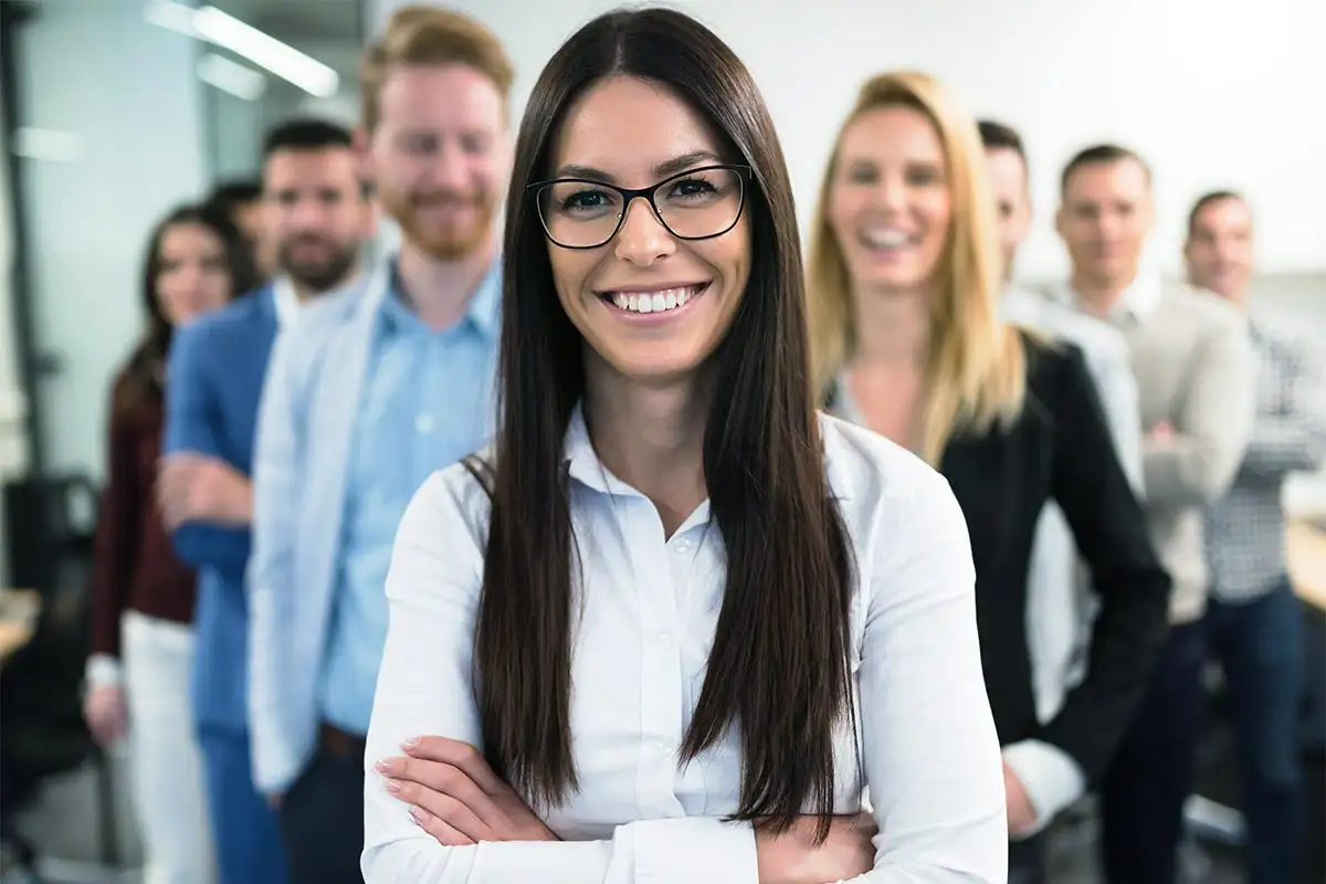 A woman with glasses stands confidently in front of a group, representing the Outpatient Center's supportive environment